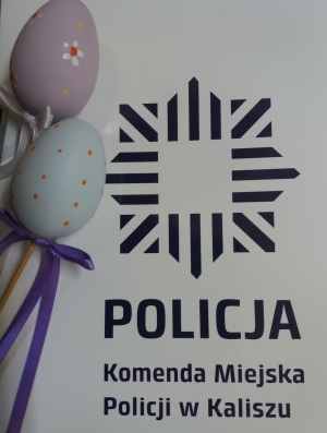 Zdjęcie kolorowe. Na białym tle, granatowy napis Komenda Miejska Policji w Kaliszu. Z prawej strony dwie kolorowe pisanki.