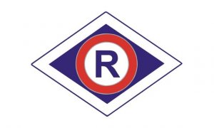 Logo ruchu drogowego - wielka litera R koloru niebieskiego na białym tle otoczona czerwonym okręgiem umieszczona na niebieskim rombie, który otacza biała obwódka