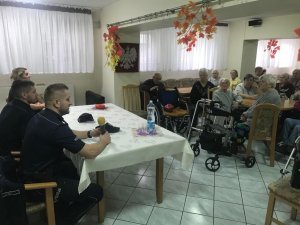 zdjęcie kolorowe, na zdjęciu policjanci rozmawiający z seniorami na temat bezpieczeństwa  w dziennym domu pomocy społecznej
