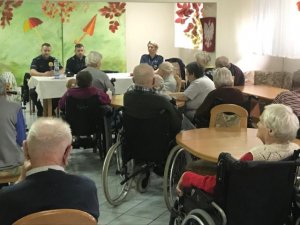 zdjęcie kolorowe, na zdjęciu policjanci rozmawiający z seniorami na temat bezpieczeństwa  w dziennym domu pomocy społecznej