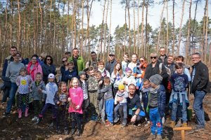 Zdjęcie kolorowe. Zdjęcie zbiorowe wszystkich uczestników akcji 100 drzew na stulecie Policji.
