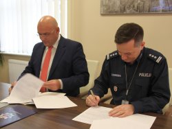 Pierwsze zdjęcie kolorowe, na nim Zastępca Komendanta Wojewódzkiego Policji w Poznaniu insp. Konrad Chmielewski w umundurowaniu służbowym koloru granatowego i Dyrektor Wojewódzkiego Szpitala Wojewódzkiego im. Ludwika Perzyny w Kaliszu.
Drugie zdjęcie kolorowe, na nim Zastępca Komendanta Wojewódzkiego Policji w Poznaniu insp. Konrad Chmielewski w umundurowaniu służbowym koloru granatowego i Dyrektor Wojewódzkiego Szpitala Wojewódzkiego im. Ludwika Perzyny w Kaliszu podpisujący umowę.
Trzecie zdjęcie kolorowe, na nim Zastępca Komendanta Wojewódzkiego Policji w Poznaniu insp. Konrad Chmielewski w umundurowaniu służbowym koloru granatowego i Dyrektor Wojewódzkiego Szpitala Wojewódzkiego im. Ludwika Perzyny w Kalisz, którzy podając rękę przekazują podpisaną umowę na świadczenie usług medycznych.