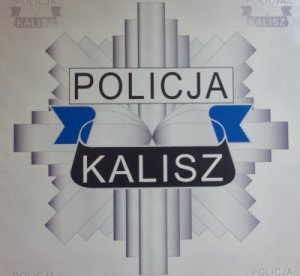 Zdjęcie kolorowe. Logo KMP w Kaliszu. Ośmioramienna gwiazda w górnej środkowej części napis &quot;POLICJA&quot;, poniżej napis &quot;KALISZ&quot;