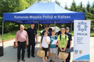 Pierwsze zdjęcie kolorowe, przedstawia rozstrzygnięcie tegorocznej edycji Rajdu Urwisa w Parku Przyjaźni, na nim uczestnicy oraz organizatorzy przedsięwzięcia- przedstawiciele Komendy Miejskiej Policji w Kaliszu , Wydziału Spraw Społecznych oraz Mieszkaniowych Urzędu Miejskiego w Kaliszu oraz harcerze ZHP w Kaliszu.
Drugie zdjęcie kolorowe, na  nim uczestnicy rajdu urwisa biorący udział w konkurencji.
Trzecie zdjęcie kolorowe, na nim trzech chłopców wykonujących zadanie podczas Rajdu Urwisa. 
Czwarte zdjęcie kolorowe, na nim chłopiec trzymający w ręku wykonany rysunek.
Piąte zdjęcie kolorowe, na nim I Zastępca Komendanta Miejskiego Policji w Kaliszu mł. insp. Tadeusz Królikowski, Zastępca Naczelnika Wydziału Prewencji i Profilaktyki Społecznej KMP w Kaliszu podkom. Witold Woźniak oraz Zastępca Naczelnika Wydziału Spraw Społecznych i Mieszkaniowych Urzędu Miejskiego w Kaliszu Janusz Sibiński oraz trzech chłopców którzy w ręku trzymają upominki.
Szóste zdjęcie kolorowe, na nim Zastępca Naczelnika Wydziału Spraw Społecznych i Mieszkaniowych Urzędu Miejskiego w Kaliszu Janusz Sibiński wręcza nagrodę drużynie biorącej udział w rajdzie urwisa oraz I Zastępca Komendanta Miejskiego Policji w Kaliszu mł. insp. Tadeusz Królikowski i Zastępca Naczelnika Wydziału Prewencji i Profilaktyki Społecznej KMP w Kaliszu podkom. Witold Woźniak.
Siódme zdjęcie kolorowe, na nim przedstawiciele Komendy Miejskiej Policji w Kaliszu,  Urzędu Miejskiego w Kaliszu oraz uczestnicy Rajdu Urwisa trzymający w ręku otrzymane upominki.