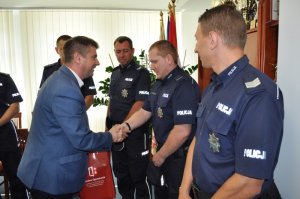Zdjęcie kolorowe. Burmistrz Gminy Opatówek Sebastian Wardęcki wręcza nagrody wyróżnionym policjantom.