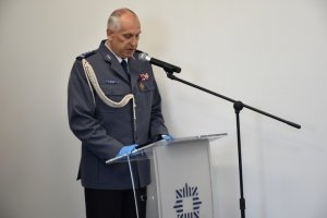 Zdjęcie kolorowe. Komendant Miejski Policji w Kaliszu insp. Dariusz Bieniek w umundurowaniu galowym podczas przemowy z okazji Święta Policji.