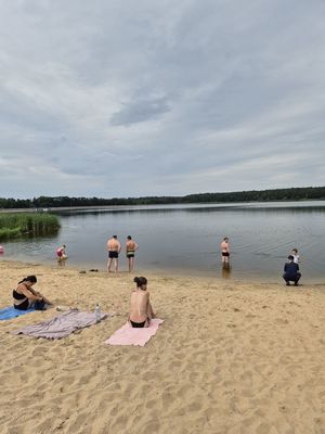 Pierwsze zdjęcie kolorowe , na nim osoby wypoczywające nad wodą oraz policjantka w tle rozmawiająca z dzieckiem.
Drugie zdjęcie kolorowe na nim policjantka rozmawiająca z osobami przebywającymi nad wodą.
Trzecie zdjęcie kolorowe, na nim policjantka z dziećmi na plaży.
Czwarte zdjęcie kolorowe, na nim policjantka z dziećmi na plaży udzielająca porad na temat bezpieczeństwa nad wodą.
Piąte zdjęcie kolorowe, przedstawia policjantkę wręczającą ulotkę ,,kręci mnie bezpieczeństwo nad wodą&#039;&#039; plażowiczom.
Szóste zdjęcie kolorowe na nim policjantka przekazuję ulotkę pani siedzącej na plaży przy zalewie Murowaniec.