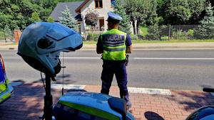 zdjęcie kolorowe, na zdjęciu policjant ruchu drogowego wykonujący czynności na drodze