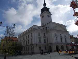 Zdjęcie kolorowe. w centralnej części Kaliski Ratusz. Po prawej stronie fragment karuzeli.