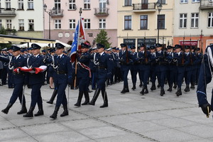 Zdjęcie kolorowe. Policjanci Kompanii Honorowej maszerujący w szyku podczas uroczystości obchodów święta Policji.