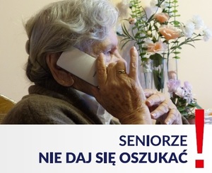 Plakat. Seniorka trzymająca przy uchu słuchawkę od telefonu. U dołu napis - Seniorze nie daj się oszukać!