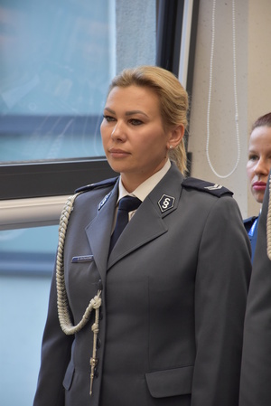 Policjantka w mundurze wyjściowym ze sznurem. Mundur koloru stalowego.