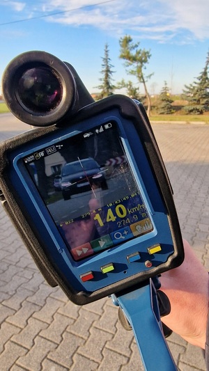 Zdjęcie kolorowe. Miernik prędkości, na którego wyświetlaczu znajduję się pojazd oraz pomiar jego prędkości 140 km/h