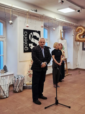 Zdjęcie kolorowe. Mężczyzna stojący przed mikrofonem, obok stoją organizatorzy konkursu "Wolność bez nałogów".