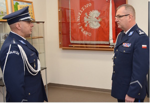 Zdjęcie kolorowe. Dowódca uroczystości składa meldunek o zakończeniu uroczystej zbiórki Komendantowi Miejskiemu Policji w Kaliszu. Policjanci stoją zwróceni do siebie twarzami.