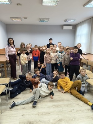 zdjęcie kolorowe zdjęcie grupowe na zdjęciu policjantka i przedstawiciel sanepidu podczas spotkania z dziećmi na półkoloniach