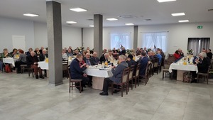 Zdjęcie kolorowe. Zdjęcie widoku sali i uczestników spotkania siedzących przy stołach.