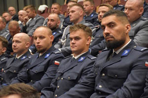 Policjanci siedzący na auli, podczas uroczystości związanej z obchodami święta Policji.