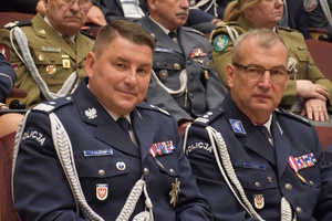 Komendant Wojewódzki Policji w Poznaniu i Komendant Miejski Policji w Kaliszu siedzący na widowni podczas uroczystości związanej z obchodami Święta Policji.